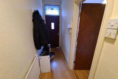 A narrow hallway featuring light wood flooring,...