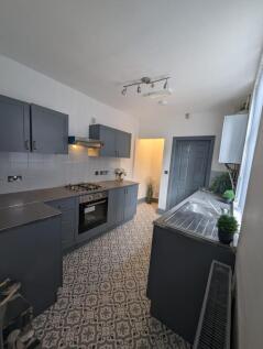 Modern galley kitchen with patterned tiled floo...
