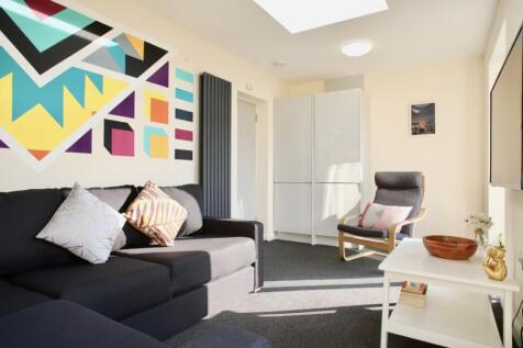 This vibrant living room features a cozy seatin...