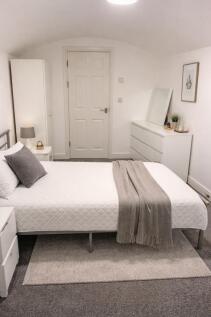 Bright, neatly styled double bedroom with a whi...