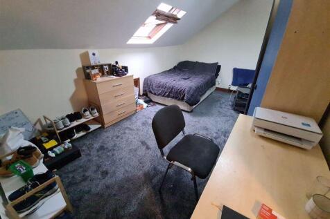 A cozy attic bedroom featuring a single bed und...