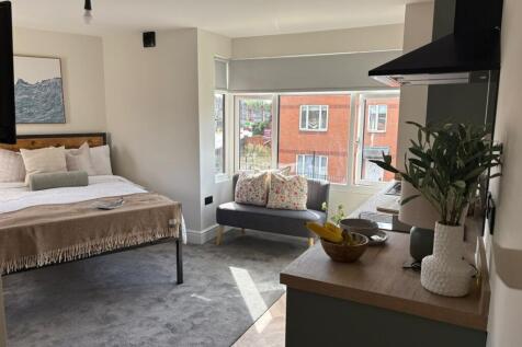 Bright, well-styled studio-style bedroom with a...