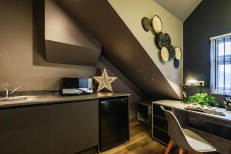 Stylish kitchenette with modern dark cabinetry,...