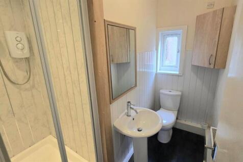 Compact bathroom with shower and white fixtures...