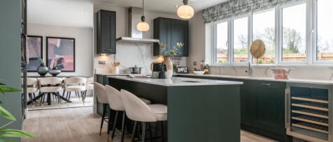 Modern open-plan kitchen with dark green cabinets, a large island, and a dining area at Oakleigh Fie