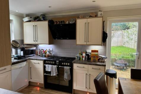 Bright, modern fitted kitchen with cream cabine...