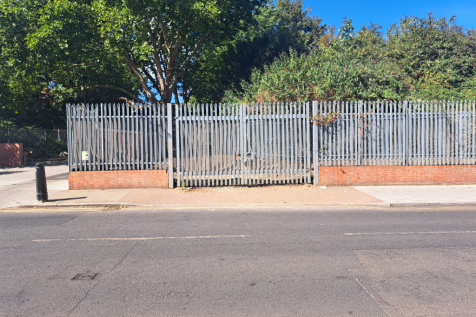 A large plot of land, with metal fencing around it.