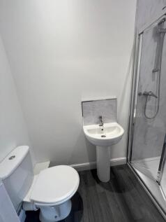 A modern, clean bathroom featuring a white toil...