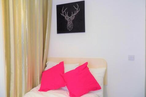 A cozy single bedroom featuring a neatly made b...