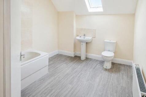 Spacious modern bathroom with bright skylight...