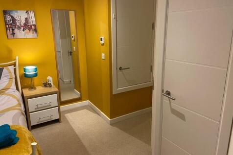 Brightly painted bedroom with a cosy bedside ta...