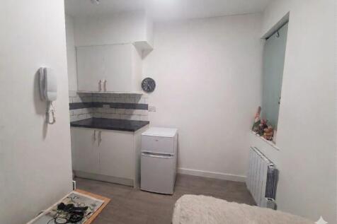 Modern studio kitchenette with sleek tiling...