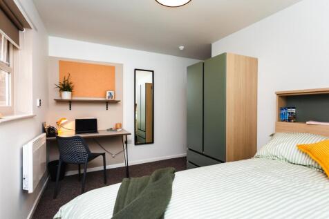 Bright, neatly styled double bedroom with a com...