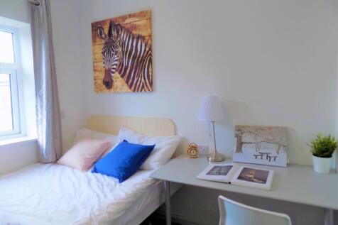 A bright and tidy single bedroom featuring a co...