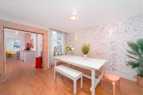 Bright dining area with white brick feature wal...