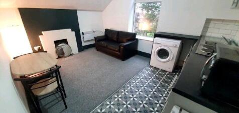 Bright studio-style living space with a comfy b...