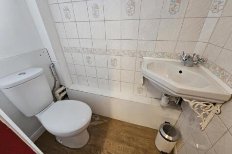 Compact bathroom with a bathtub, corner sink an...