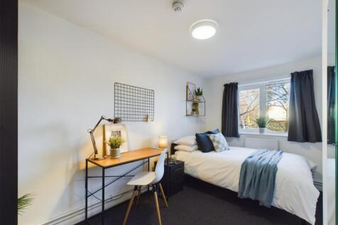 A bright and inviting double bedroom with a com...