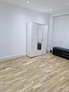 Spacious room with modern flooring and storage...