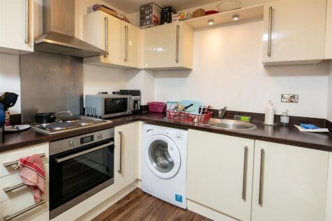 Modern fitted kitchen with integrated oven, hob...