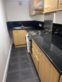 A modern kitchenette with stylish cabinetry and...