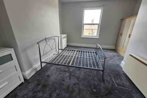 A bright and tidy bedroom featuring a metal bed...