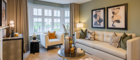 Bright living room with a large window, cream sofa with decorative cushions, abstract art on the wal