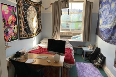 Bright bedroom with large desk and vibrant deco...