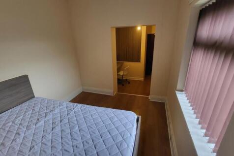 Bright, simply furnished bedroom with a double ...