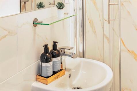 Elegant marble-style tiling and modern vanity...