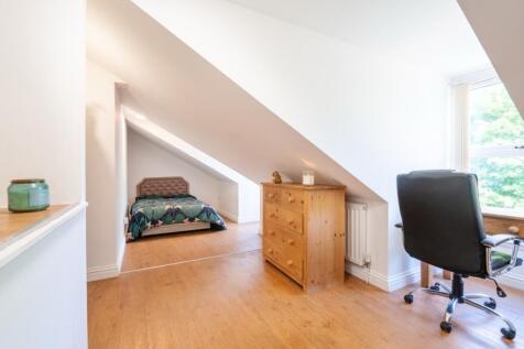 Bright and spacious bedroom featuring a cozy si...