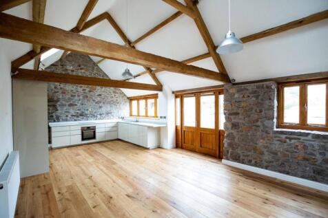 Bright, open-plan kitchen with exposed timber b...