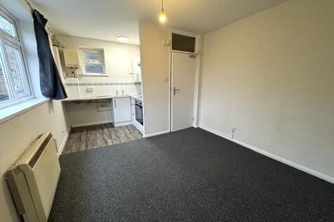 Well-lit studio room featuring a compact fitted...