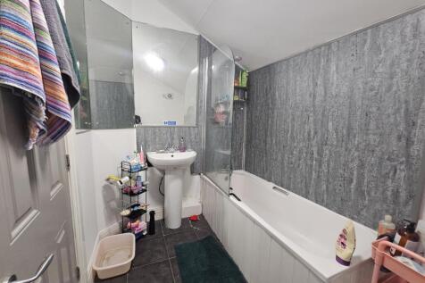 A clean and modern bathroom featuring a bathtub...