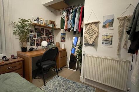 Cozy furnished bedroom with a desk workspace, b...