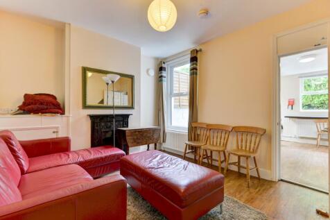 Bright, neatly presented living room with a red...