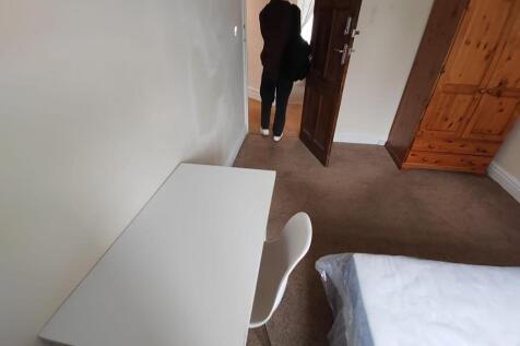 Bright, simply furnished bedroom with a study d...