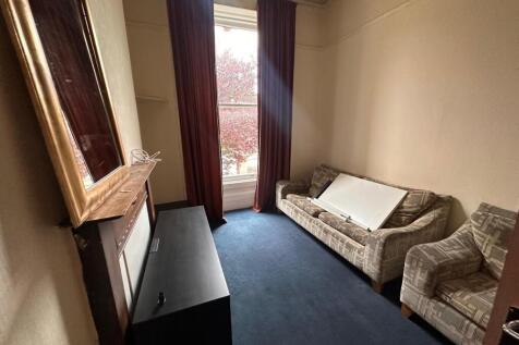 Bright front-facing living room with a large sa...