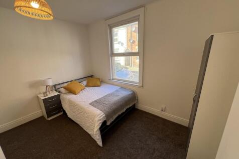 A well-lit, cozy double bedroom featuring a com...