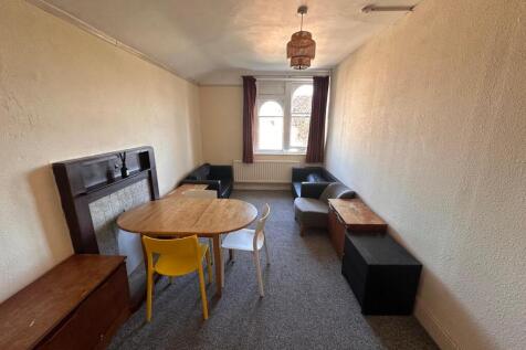 Long, narrow living room with a central wooden ...