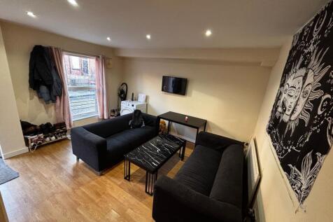 Bright, modern living room with two black sofas...