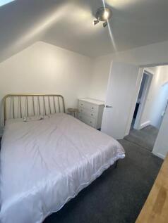 Bright, tidy double bedroom with a metal headbo...