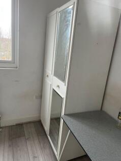 Bright room with mirrored storage and large des...