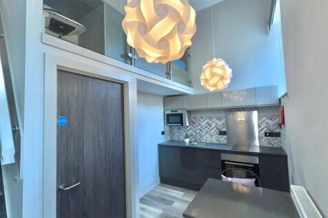 Modern kitchenette with dark gloss cabinets, bu...