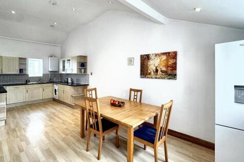 Bright, spacious kitchen with wooden dining are...