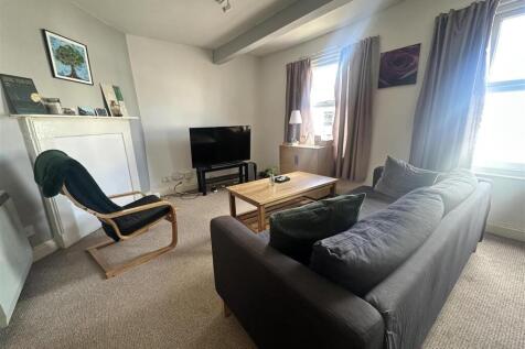 Bright lounge with comfy sofa and large TV....