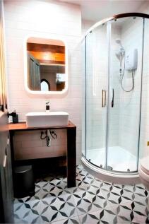 Modern bathroom with curved shower and patterne...
