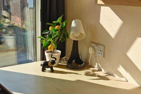 Sunlit workspace by a large window with a tidy ...