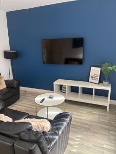 Contemporary living room with a deep blue featu...