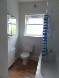 Bright and clean bathroom featuring a bathtub, ...